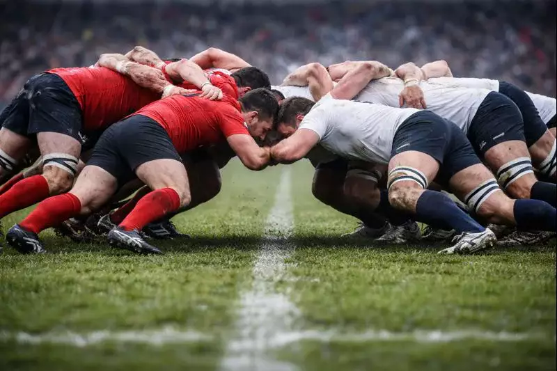 Mêlée intense entre deux équipes de rugby sur terrain de gazon